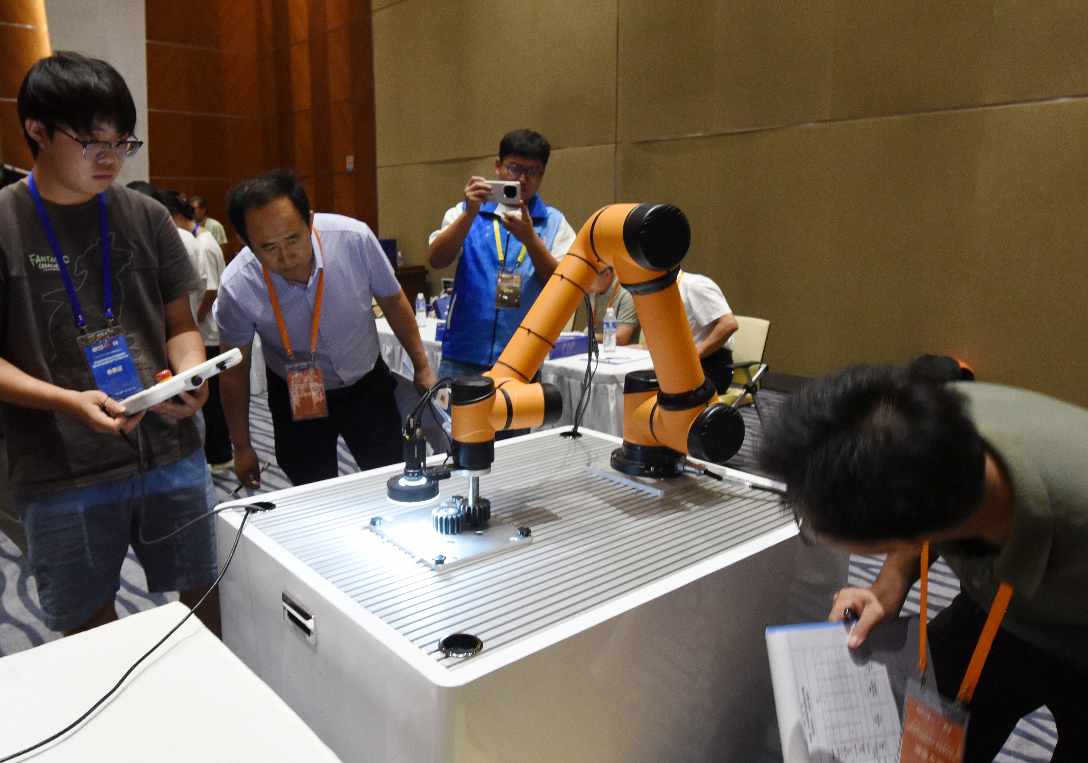2025年中國大學(xué)生機(jī)械工程創(chuàng)新創(chuàng)意大賽智能精密裝配賽京津冀魯聯(lián)賽現(xiàn)場(chǎng)，評(píng)委對(duì)參賽選手進(jìn)行實(shí)操調(diào)試評(píng)比。
